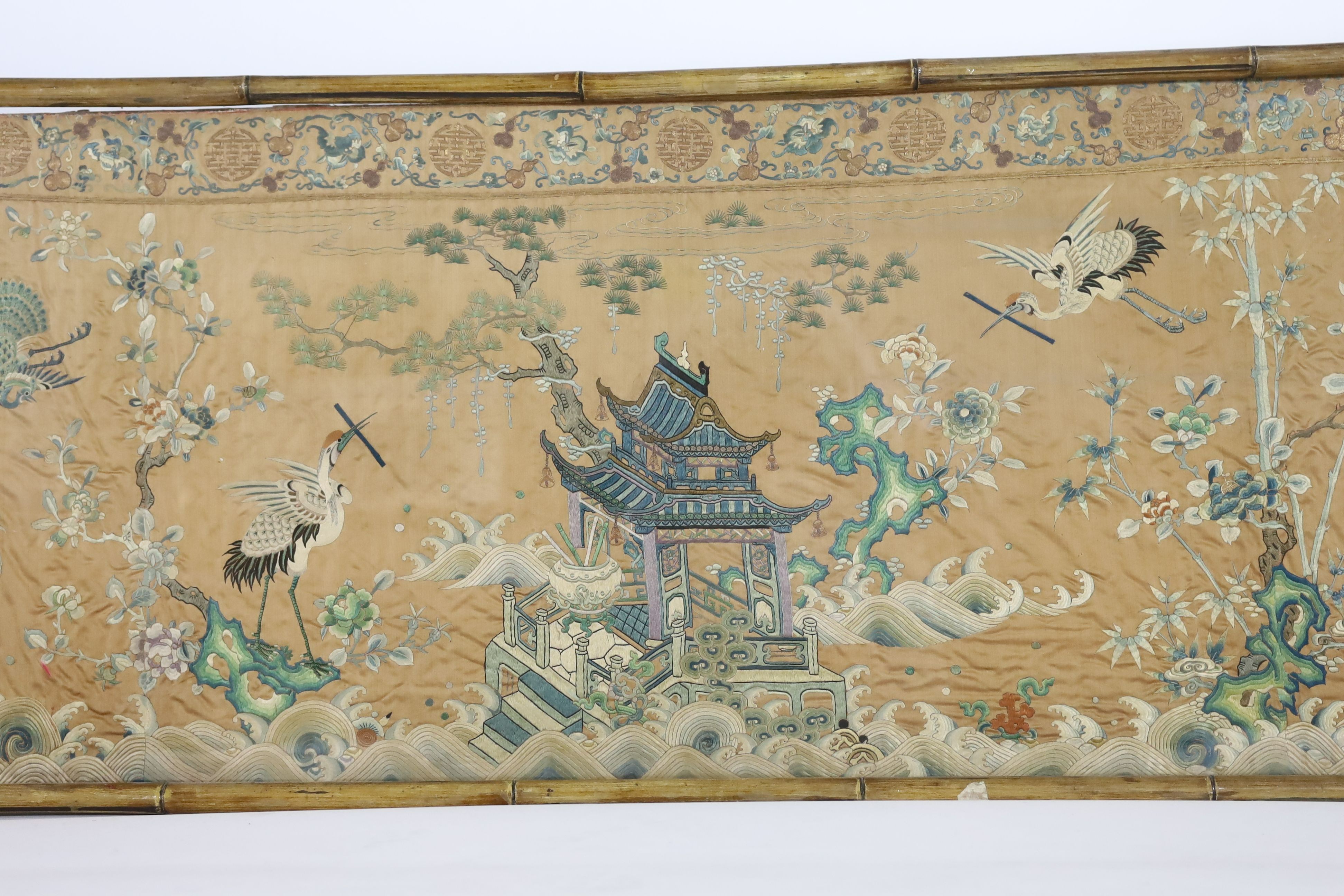 A Chinese apricot ground embroidered silk table frontal, late Qing dynasty, 58cm x 178cm, now trimmed and framed